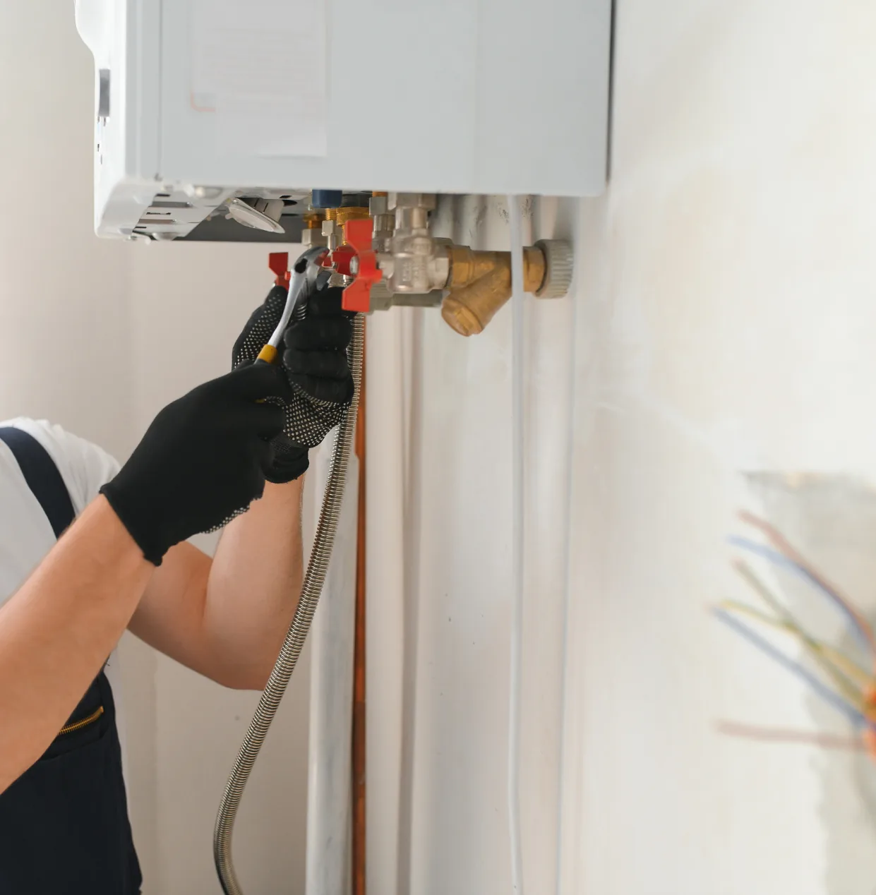 Technician servicing the valves on a wall-mounted boiler