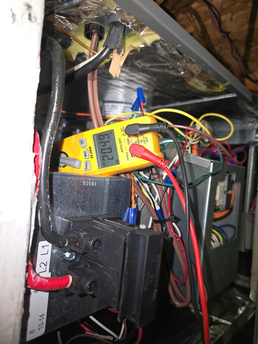 Clamp meter measuring amperage inside an air handler